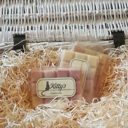 Three hand-made rectangular Wax Melts. Each is coloured a delicate rich brown blending to a light creamy yellow, resting in a basket of straw. Imagine yourself beside the fire as the horse chestnuts roast.