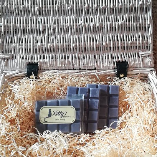 Three hand-made rectangular Wax Melts. Each is coloured a deep fig blue, the melts are resting in a basket of straw. Each melt is an enchanting mix of succulent plump figs, cherries and raspberries blended with cassis on a bed of creamy coconut that gives a luxurious warming Mediterranean feel that everyone will enjoy.