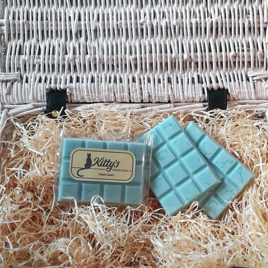 Three hand-made rectangular Wax Melts all Duck Egg Blue, resting in a basket of straw. Each melt bursting with the childhood feeling of playing hide-and-seek in between the laundry sheets blowing in the spring breeze. 